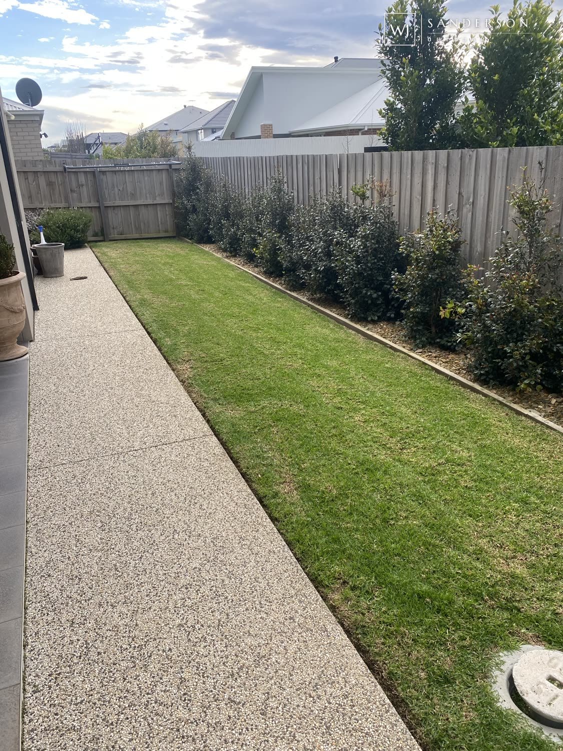 Lawn maintenance in Geelong: a new lawn strip with young hedging, planted and maintained by WJ Sanderson Outdoor